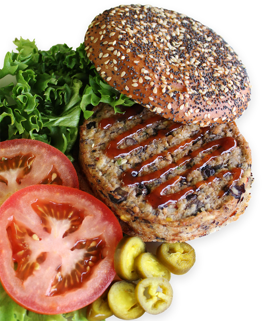 A veggie burger with ketchup shown next to the bun, tomatoes, lettuce and pickles